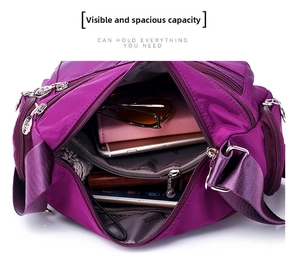 Internal view of purple nylon crossbody bag showing multiple pockets and large capacity