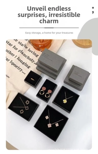 Macro detail of elegant clover necklace and jewelry set in premium dark gray gift box