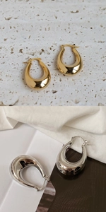 Macro shot of metallic chunky drop earrings in polished gold and silver finishes