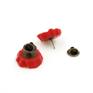Broche coquelicot en résine rouge avec fermoir papillon en bronze sur fond blanc