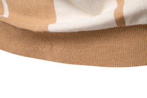 Detailed macro view of camel and off-white striped knit fabric with ribbed hem finish
