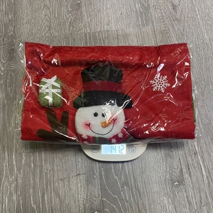 Detailed view of snowman burlap Christmas gift bag on scale showing 141.2g weight