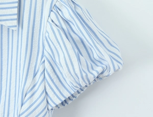 Macro detail of blue and white vertical stripe seersucker fabric with puff sleeve texture