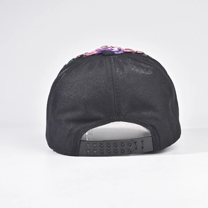 Dettaglio di strass multicolore su un cappello da baseball nero glitterato con chiusura