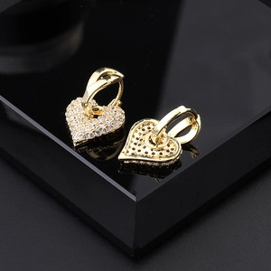Orecchini a cuore in oro minimalisti con zirconi bianchi su base nera con riflesso lucido