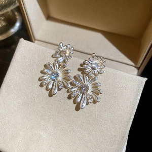 Detail of double daisy pearl earrings with gold petals and sparkling zircons