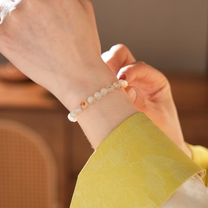 Vue détaillée d'un bracelet en perles de cristal au poignet avec minéraux naturels