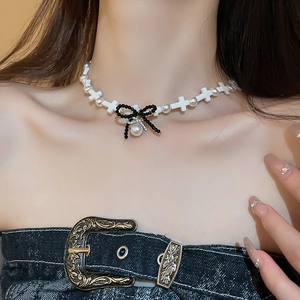 Cross pearl choker necklace with black resin bow and crystal teardrop pendant on model