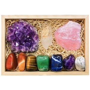 Detailed top view of natural chakra crystals set in a wooden box with raw and polished stones