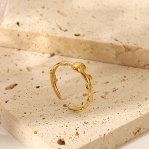 Dettaglio anello a ramo dorato regolabile con texture a bocciolo su pietra