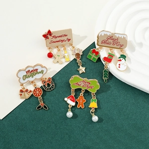 Macro shot of colorful enamel Christmas brooches with festive charms on golden metal