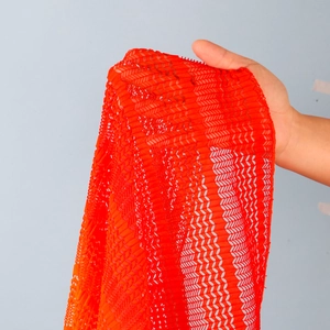 Dettaglio del pizzo rosso geometrico traforato con trama a rete semitrasparente