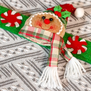 Detailed close-up of a plush gingerbread man curtain tieback with festive knit textures