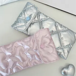 Close-up of heart quilted metallic silver and pink soft sunglasses storage cases