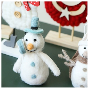 Détail macro d'un bonhomme de neige artisanal en feutre de laine à la texture douce