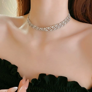 Gros plan du collier ras-du-cou argenté avec strass brillants porté par un modèle