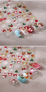 Makro-Detail von 3D-Weihnachtsnagelstickern mit Weihnachtsmann- und Schneeflockendesigns