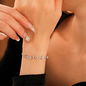 Elegant silver bracelet with square purple zircons and diamond halo on female wrist