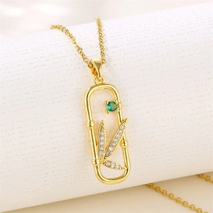 18K gold leaf pendant necklace with green zircon and bamboo design on display stand
