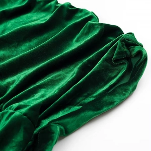 Detailweergave van groene fluwelen stof met elegante plooien en zachte, glanzende textuur