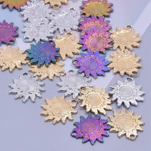Macro detail of sun-shaped stainless steel charms in silver gold and iridescent finishes