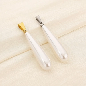 Detailed macro view of white drop-shaped pearl pendants with gold and silver metal clasps