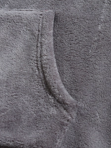 Detailed close-up of grey coral fleece fabric with premium stitching on hoodie pocket