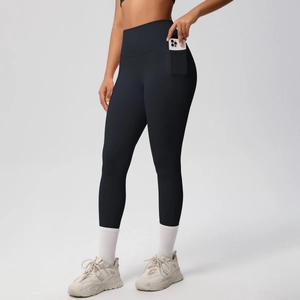 Detail view of high waisted yoga pants with a functional side pocket holding a smartphone