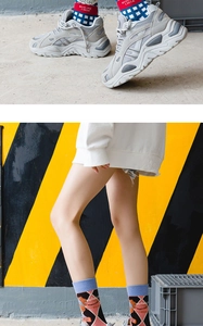 Detailed view of Lolita style mid-calf socks with chunky sneakers on street background