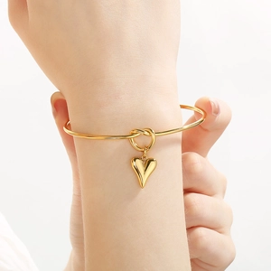 Fashionable gold stainless steel open bangle with a polished heart charm for women