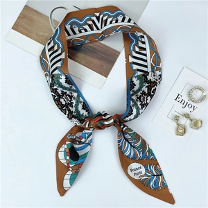 Detail of caramel silk scarf showing geometric patterns and peacock feather prints
