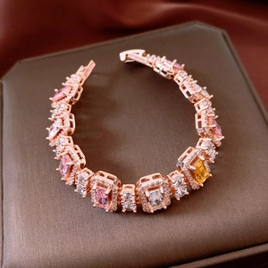 Detail of rose gold bracelet with pink and yellow square zircons on a jewelry box