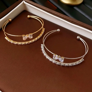 Double-layered zircon heart bow bracelet in gold and silver finish with baguette stones