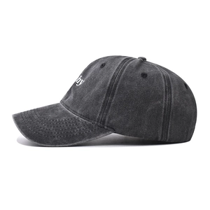 Dettaglio del cappellino in cotone lavato grigio antracite con ricamo bianco sul lato