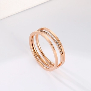 Detailed macro view of triple-layered rose gold titanium ring with pavé zircon setting