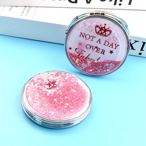 Vue détaillée du miroir de maquillage sable mouvant rose avec logo couronne