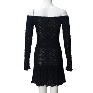 Close-up of black lace dress showing hollow floral pattern and ruffled hemline detail