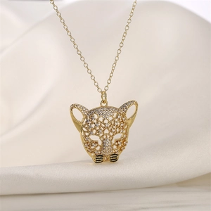 Detailed view of a gold-plated leopard head pendant with micro-pave zircons on white silk