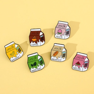 Flat lay of six cute cartoon milk box enamel pins in peach, coffee, and banana flavors
