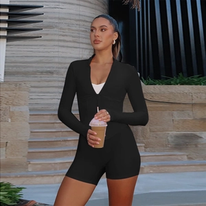 Close-up of black long sleeve romper featuring a deep V-neckline with a front zipper detail