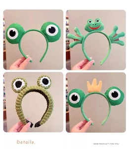 Detail view of four unique cartoon frog headbands featuring plush and knitted designs