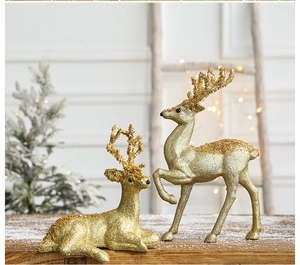 Macro detail of gold glitter reindeer figurines set against festive snowy background