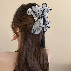 Détail d'une pince à cheveux élégante avec encre de chine et long gland noir soyeux