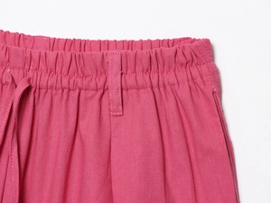 Gros plan du pantalon en lin rose avec taille élastique et cordon de serrage assorti