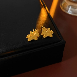 Macro shot of gold plated Qilin studs on black leather box with textured scale details