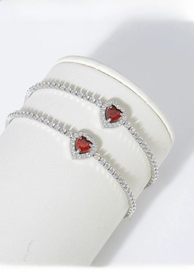 Close-up of red heart-shaped gemstone bracelet with sparkling white cubic zirconia