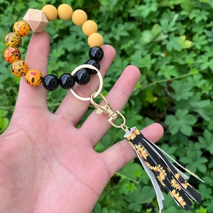 Detail of beaded keychain bracelet featuring sunflower tassel and leopard print beads
