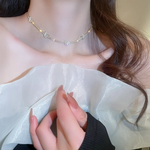 Close-up of sparkling silver butterfly pendant necklace worn by a female model