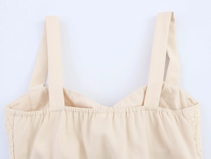 Detail of beige lace camisole showing pleated chest design and soft fabric texture
