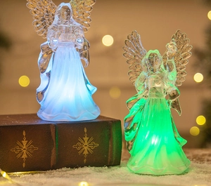 Macro view of crystal acrylic angel figurines with glowing blue and green LED lighting